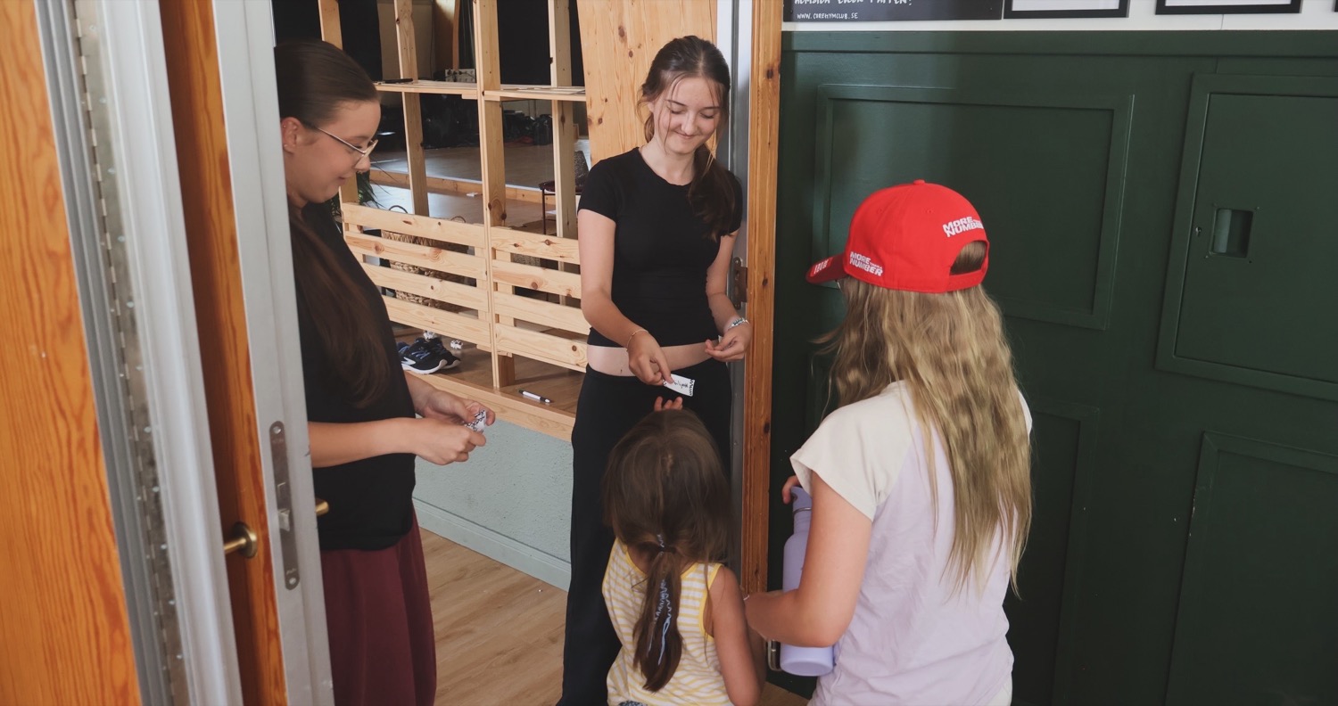 Barn checkar in hos pedagogerna vid ankomsten till lägret